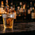 Copo Shot Descartável 25ml com whisky em balcão de bar — RAS Embalagens