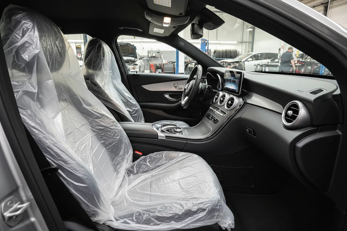 Capas brancas em plástico PEBD colocadas nos bancos da frente de um automóvel