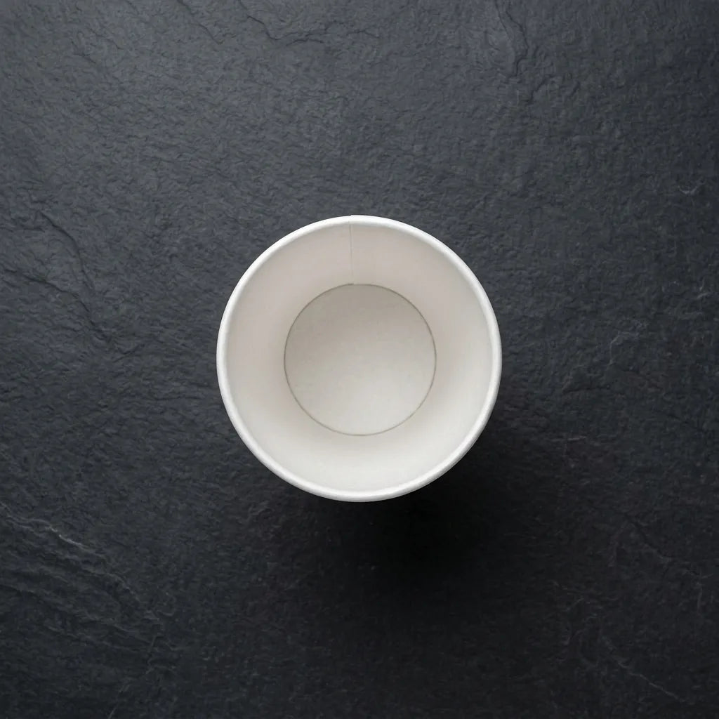 Copo de café de papel de 90ml sobre fundo escuro