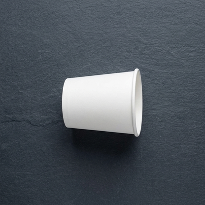 Copo de papel para café de 120ml sobre fundo escuro
