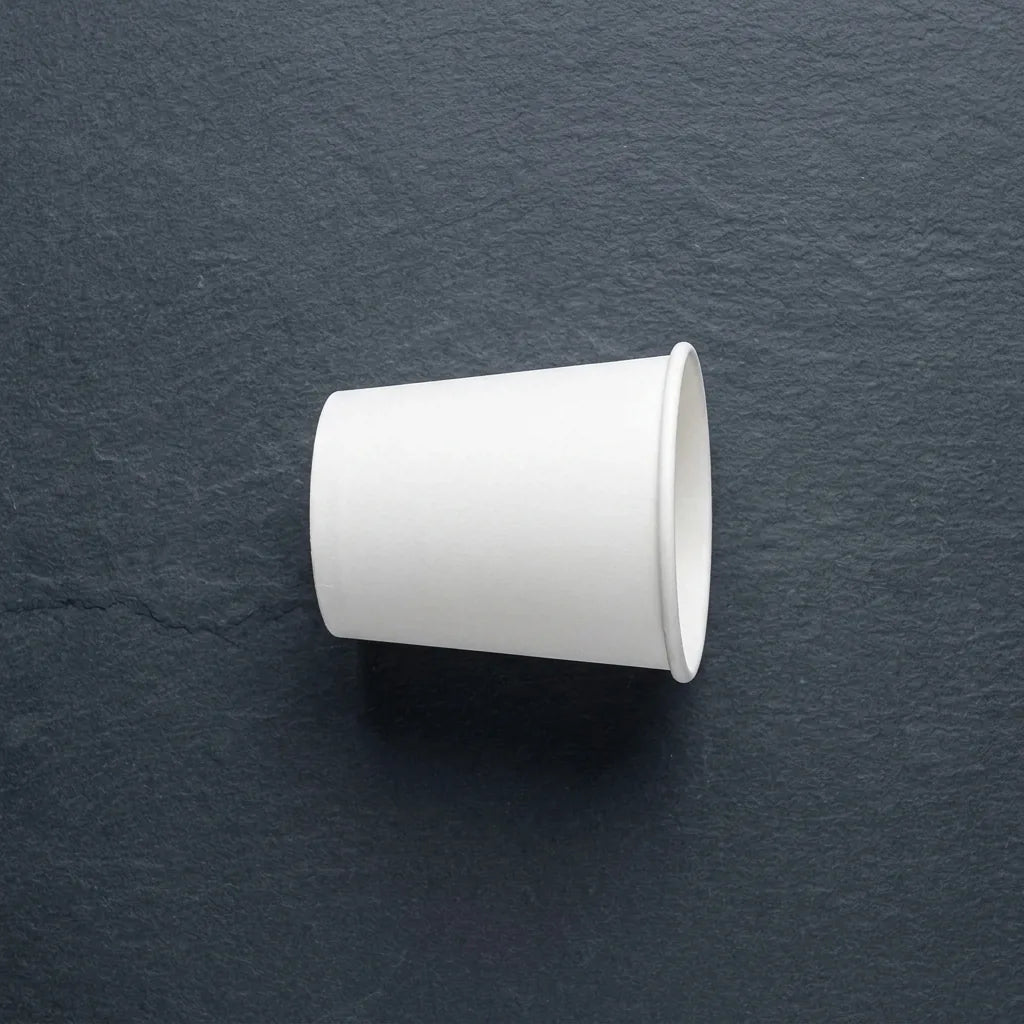 Copo de papel para café de 120ml sobre fundo escuro