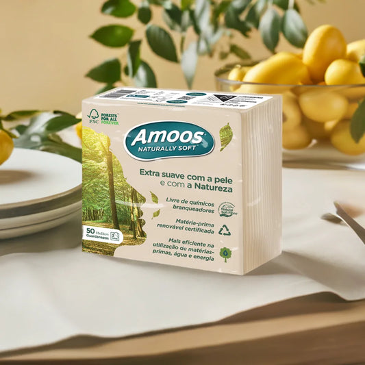 Pack de guardanapos Amoos Naturally Soft 33x33 numa mesa posta, com limões e folhas ao fundo