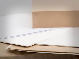 Folhas de papel multicozeduras branco e kraft empilhadas — RAS Embalagens