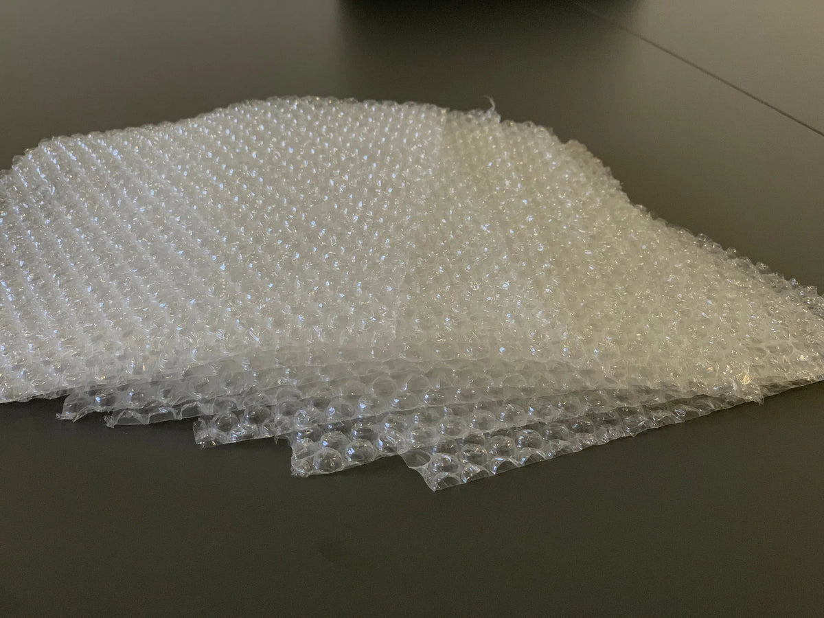 Folhas de plástico bolha de ar empilhadas sobre uma mesa escura