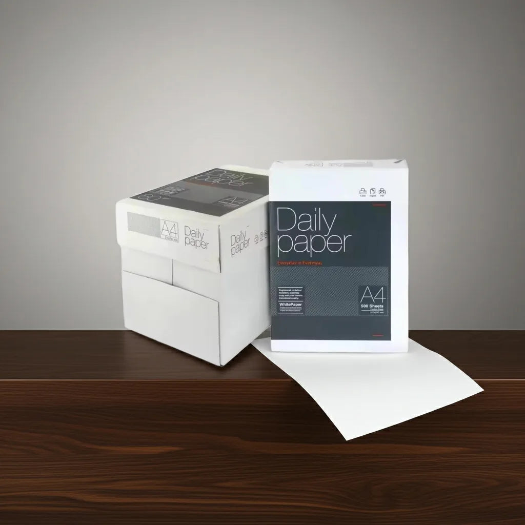 Caixa e resma de papel de fotocópia A4 75 g Daily Paper numa mesa de madeira